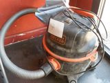 un aspirateur posé par terre près d'une fenêtre