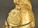 helmet of a roman soldier with a crest and shield on a stand