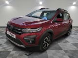 une voiture rouge garée dans un garage au sol en damier