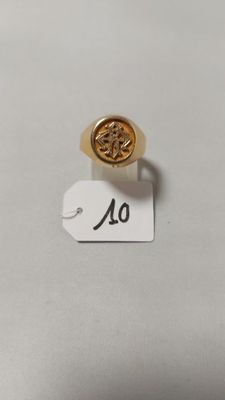 un gros plan d'une bague en or ornée d'une petite fleur