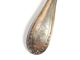 a silver spoon that is sitting on a white surface