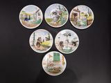six plates with pictures of people and animals on them on a black surface