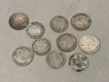 Six types différents de pièces d'argent sont disposés sur une table.