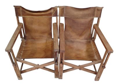 deux chaises en cuir marron assises l'une à côté de l'autre sur une surface blanche