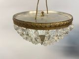 a gold plate with a crystal chandelier hanging from it ' s ceiling