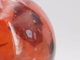 a close up of a red vase with a ladybug on it