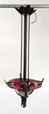 a bird feeder hanging from a metal pole with a bird on it
