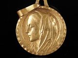 l'image d'une médaille d'or sur laquelle figure le visage d'une femme