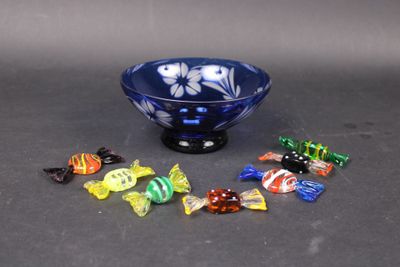 a blue bowl filled with assorted candis on a table