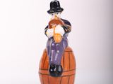 a figurine of a man sitting on top of a barrel