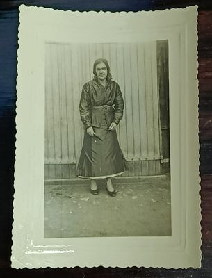 une vieille photo d'une femme debout devant un mur