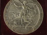 a silver medal in a wooden box on a table
