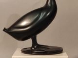 sculpture of a black bird on a marble base on a gray background