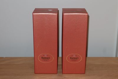 deux boîtes rouges posées l'une à côté de l'autre sur une table en bois