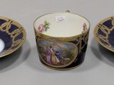 two cups and a saucer sitting on top of a table