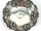 an antique silver plate with a floral design on the rim