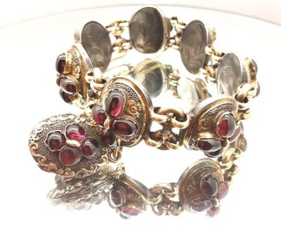 a close up of a bracelet with red stones on it