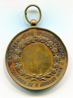 un gros plan d'une médaille posée sur une surface blanche, sur fond blanc