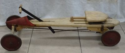 une petite voiture en bois posée sur un sol carrelé