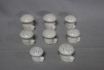 a lot of small white ceramic mushrooms on the table