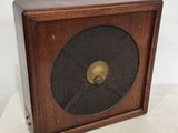 une vieille horloge en bois avec un cadran noir sur un fond blanc
