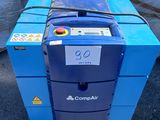 un gros plan d'une machine bleue posée au sommet d'une pile de sacs