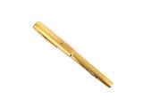 a gold colored pen sitting on top of a white surface