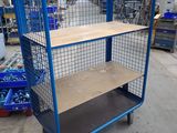 blue wire mesh shelf cart with wooden shelves in a warehouse