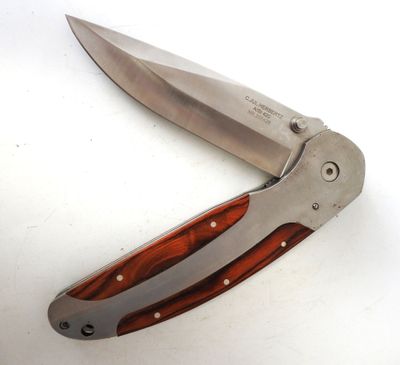 a knife with a wooden handle on a white surface