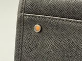 the back pocket of a purse with a button on it