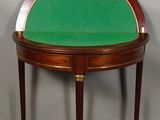 a small table with a green top and gold trim around it