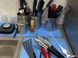 Plusieurs ustensiles de cuisine sont alignés sur un torchon bleu