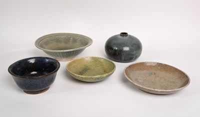 four bowls and a bowl are sitting on a white surface