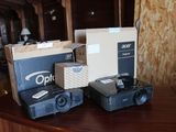 trois caméras et un projecteur posés sur une table