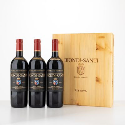 three bottles of red wine in front of a wooden box