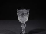 a wine glass sitting on a table with a black background