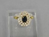 a yellow gold ring with a black diamond surrounded by white diamonds