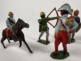 three figurines of men on horses with a bow and arrow