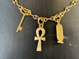 an image of a gold necklace with a key and an ankh on it