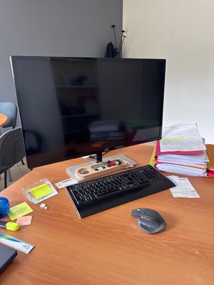 a desk with a computer, keyboard, mouse, and other items on it