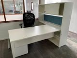 a white desk with a black chair next to a window