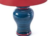 a blue and red table lamp with a red shade on it
