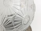 a glass ball on a metal stand on a white surface