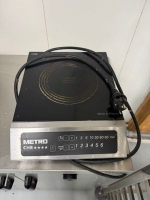 une plaque de cuisson noire et argentée, sur laquelle se trouve un brûleur noir