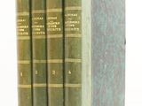 trois livres verts sont empilés les uns sur les autres sur une surface blanche