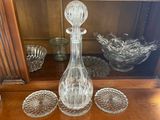 a glass decanter sitting on a table next to other glass dishes
