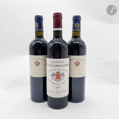 trois bouteilles de vin rouge posées l'une à côté de l'autre sur une surface blanche