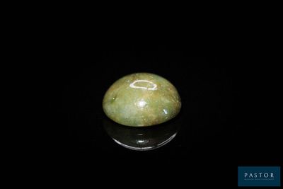 une image représentant une pierre de jade verte posée sur une surface noire