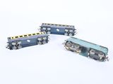 three miniature trains sitting next to each other on a white surface