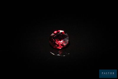 un diamant rouge sur une surface noire